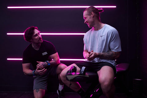 Two workout partners talking in the gym