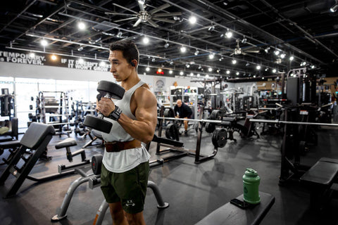 Weightlifter using Versa Gripps and a lifting belt while he lifts weights