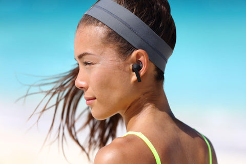 Woman wearing earbuds in the gym